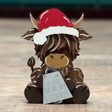 Load image into Gallery viewer, Hand-painted chunky Highland cow shelf sitter wearing a Santa hat, featuring whimsical farmhouse-style Christmas décor.