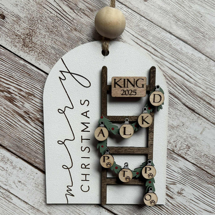 Personalized hand-painted Christmas ornament featuring a ladder, garland, and family initials, celebrating love and togetherness.